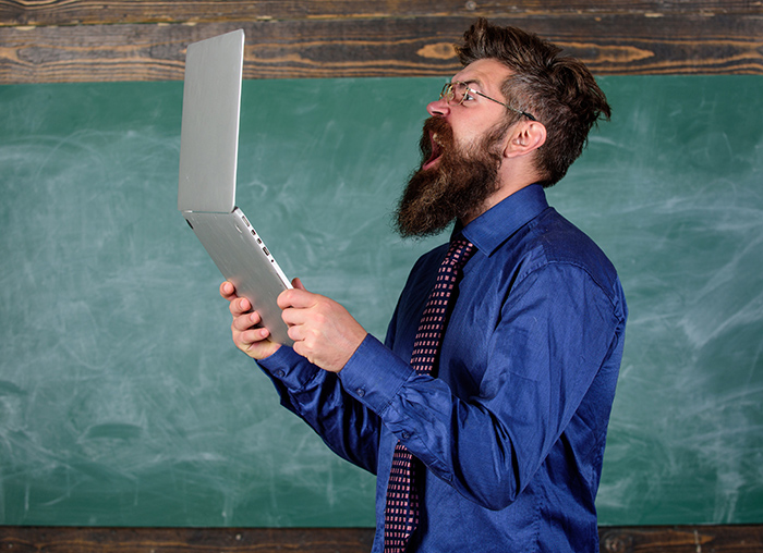 A bearded man screaming at his laptop
