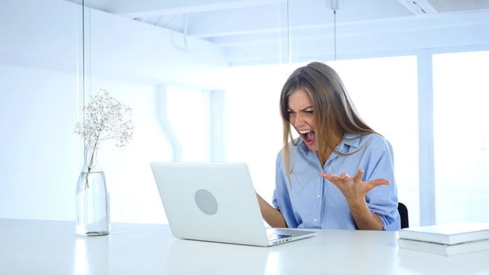 An angry woman freaking out at her computer